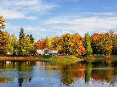 Moskova 'daki güzel Ostankino Parkı, sonbahar göleti kıyıda beyaz bir kafe ve suda bir yansıma..