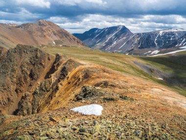 Kırmızı yuvarlak kayaları olan güzel bir dağ manzarası. Büyük kaya oluşumu, farklı kaya oluşumları ve toprak katmanları. Uzak dağ yaylaları.