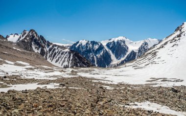 Beyaz karlı, siyah kayalıklı, temiz bir dağ manzarası. Karlı dağ yamacının minimalist arka planı.