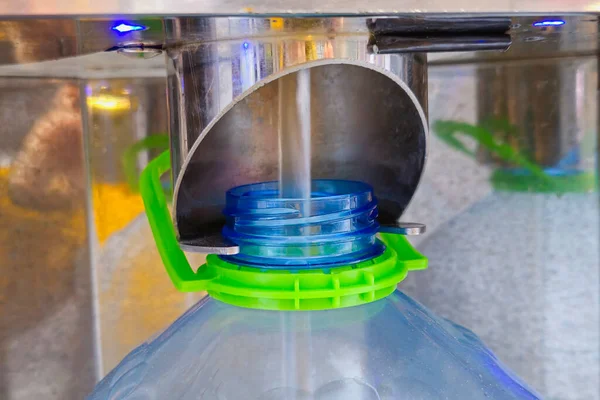 Filtrelenmiş su, içme suyu kutusundaki plastik bir şişeye dökülüyor. Temiz su sistemindeki suyu kapat..