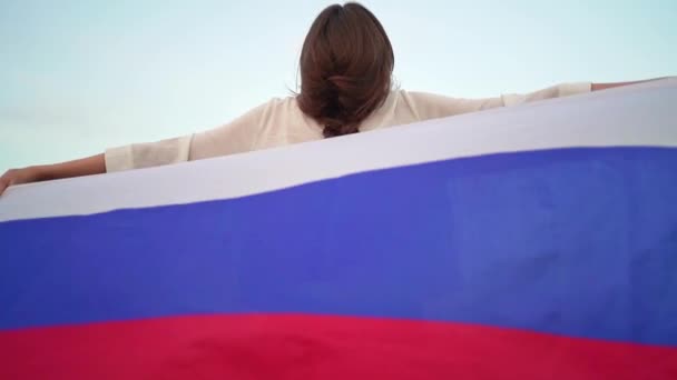 La bandera de Rusia detrás de la joven mujer hermosa — Vídeo de stock