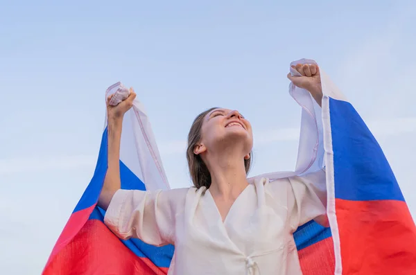 Rus bayrağı taşıyan vatansever bir kadın zaferini kutluyor. Mutluluk ve bağımsızlık