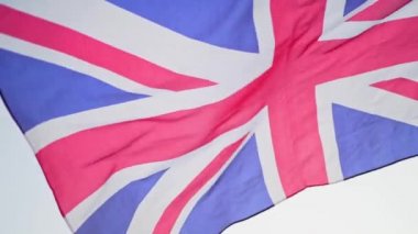 Büyük Britanya bayrağı, günbatımında gökyüzüne karşı rüzgarda dalgalanır. Yavaş çekim, İngiltere 'nin ulusal sembolü.
