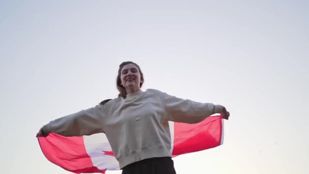 Canada vlag zwaaiend. Mooie jonge vrouw danst met Canadese vlag — Stockvideo