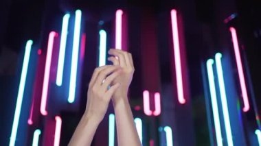 Dans eden genç bir kadının elleri. Neon lambalara karşı hip hop dansı