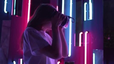Sanal gerçeklik gözlüğü takan bir kadın. Neon arkaplanda VR kulaklık