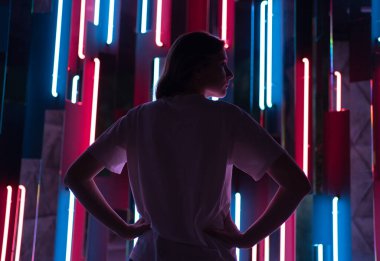 Neon ışıklı genç bir kadın profilinde siluet. Gece kulübünde renkli bir arka plan