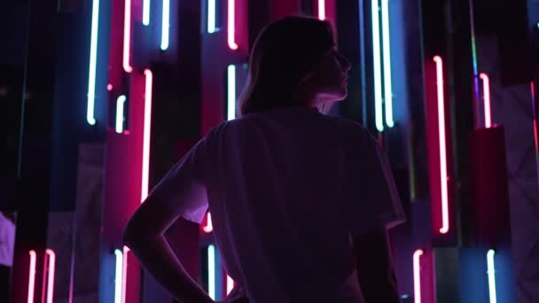 Sziluett egy neon fényű fiatal nő profiljában. Stílusos színes háttér nightclub — Stock videók