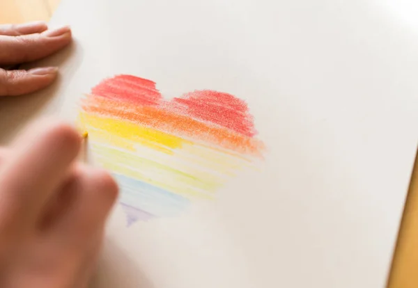 Un símbolo de amor comunidad LGBT. Dibujar un corazón de arco iris sobre papel blanco —  Fotos de Stock