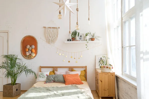 Una acogedora habitación a la luz del sol. Hermosa cama en un interior moderno —  Fotos de Stock