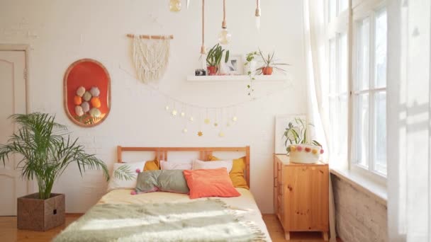 Una acogedora habitación a la luz del sol. Hermosa cama en un interior moderno — Vídeos de Stock
