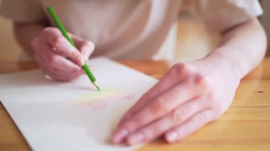 Kişi kalemli beyaz kağıda çok renkli bir kalp çizer. Gökkuşağı sembolü, azınlık toplumu