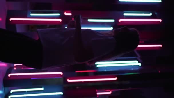 Pionowe wideo - sylwetka tancerki w ciemnym neonowym pokoju, relaksujący taniec — Wideo stockowe