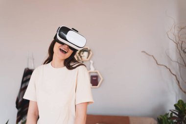 Sanal mutluluk. Genç kadın sanal gerçeklik kulaklığıyla gülüyor.