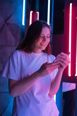 Dikey atış - başarı ve kazanan. Neon lambalı genç kadın şaşırdı.