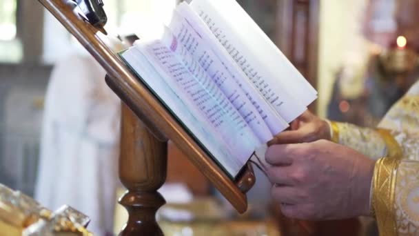 Un prete legge una bibbia in chiesa. Una cerimonia religiosa. La fede in Dio — Video Stock