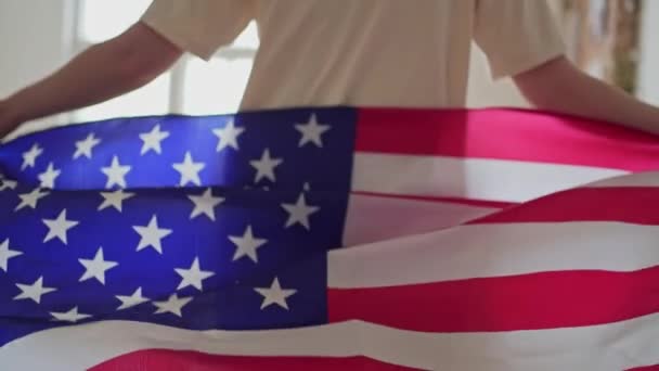 La bandera de Estados Unidos ondea. La persona va con el símbolo nacional. Mujer patriótica — Vídeos de Stock