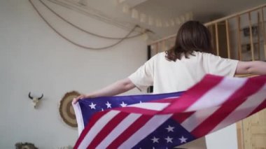 Amerika 'nın bağımsızlığı. Bir kadın Amerikan bayrağıyla dönüyor. Ulusal Gün