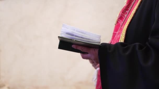Ένας ιερέας σε μια εκκλησία. Η Βίβλος σε πρώτο πλάνο. Θρησκευτική τελετή στο Χριστιανισμό — Αρχείο Βίντεο