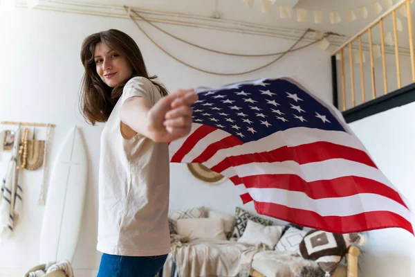 С нами. Независимость и иммиграция. Красивая молодая женщина позирует с национальным флагом Америки — стоковое фото