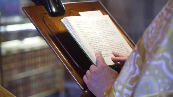 La foi, la Bible et Dieu. Prêtre lit livre sacré lors de la cérémonie — Video