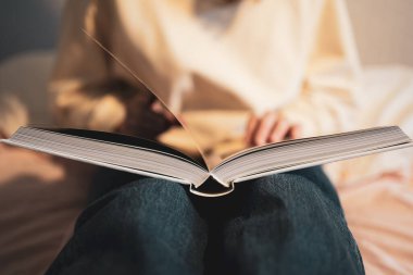 Açık kitap. Bu kişi edebiyat okuyor. Yakın plan. Kütüphanedeki öğrenci, eğitim.