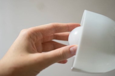 Elektrikçinin elindeki lamba. Evde elektrik teknolojisi var. Kapalı alanda aydınlatma