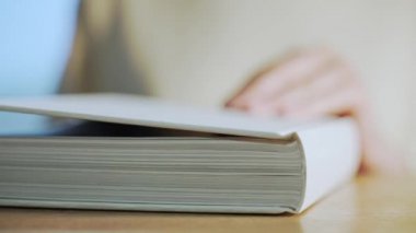 Tahta masadaki beyaz kitap. Dinlenirken edebiyat okuyorum. Eğitim