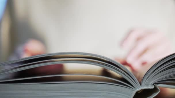 A ler um livro. Uma pessoa vira páginas de papel close-up — Vídeo de Stock