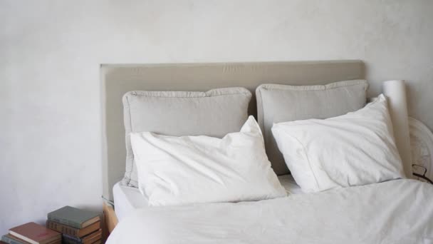 Apartamento. Uma cama acolhedora com almofadas. luz do dia. 4K 10 bits. — Vídeo de Stock