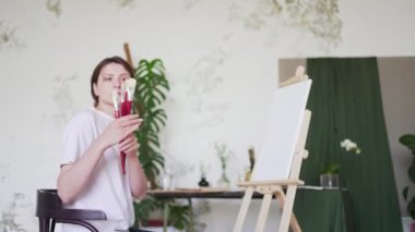 Bir kadın sanatçı fırçaları çizim için kontrol eder. Yetenekli bir ressam. Profesyonel yaratıcı eğitim