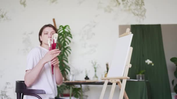Eine Künstlerin prüft Pinsel auf Zeichnung. Talentierte Malerin. Kreative Berufsausbildung — Stockvideo