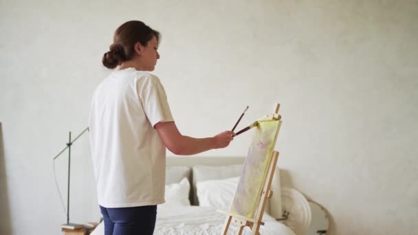 Un hobby creativo. Ispirazione e creatività. Una giovane donna dipinge un quadro — Video Stock