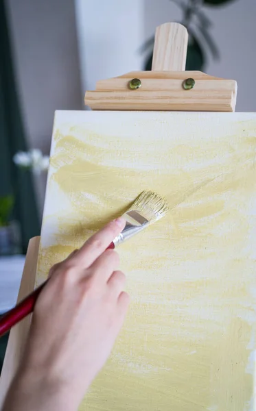 Pintura al óleo. El artista tiene la idea de dibujar. Una mujer aplica pintura amarilla a un lienzo blanco — Foto de Stock