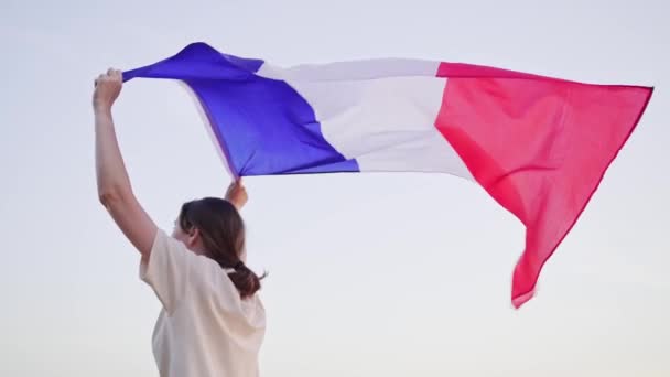 Frankrike. Frihet. Nationell flagga över huvudet på en ung kvinna som går — Stockvideo