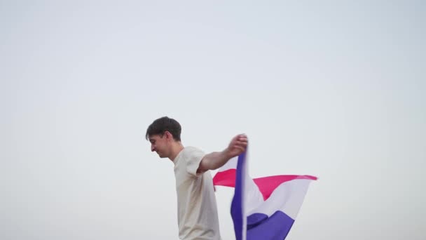 Fransa bayrağı taşıyan bir adam. Olimpiyatlarda vatansever. Ulusal sembol el sallaması — Stok video