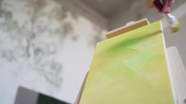 Renkli bir sanat eseri yaratmak. Profesyonel ressam sehpaya resim çizer.