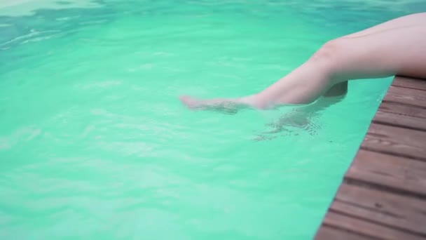 Nogi szczupłej kobiety w basenie. Letnie przyjęcie. Woda pod słońcem. Zabawa i relaks — Wideo stockowe