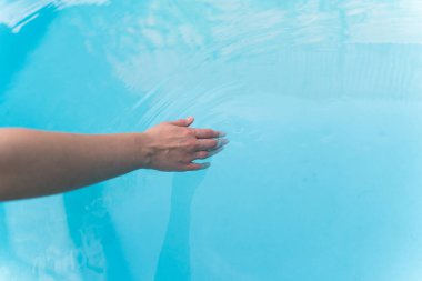 Genç bir kadın havuzda suyun üzerinden kayıyor. Yaz tatilinde otel havuzunda dinlen.