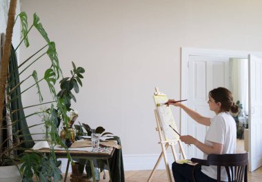 Girişimci sanatçı. Genç bir kadın stüdyoda bir resim çiziyor. Profesyonel yaratıcılık