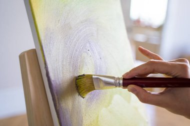 Sanatçı tuval üzerinde bir fırçayla çalışır. Genç bir girişimci. Yaratıcı meslek