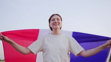 4K, 10 bit. Bayrağı olan bir vatansever. Fransa. Genç bayan mutlu ve gülümsüyor.