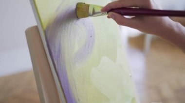 Sanatçı bir resim çizer. Yakın plan. Galeride çağdaş sanat eserleri var. Oluşturma çalışmaları