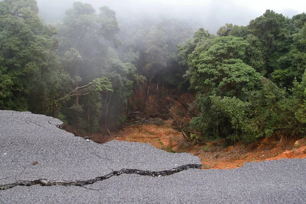 Dağlık toprak kaymasından kaynaklanan sağanak yağış nedeniyle asfalt yolu çöktü