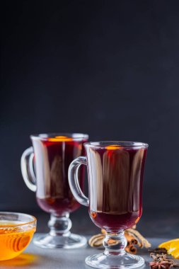 Tahtada sıcak şarap. İki bardak sıcak şarap ve malzemeler. Şarap ve ballı Noel içkisi