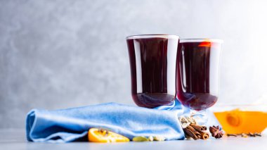 Noel içkisi. Gri arka planda sıcak şarap. İki bardak sonbahar şarabı mavi bir peçetenin üzerinde. Boşluğu kopyala