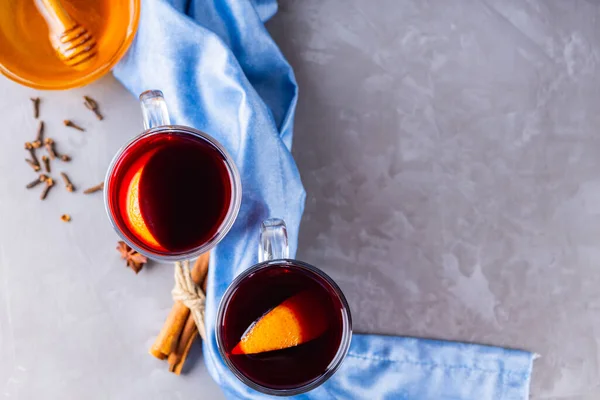 Mulled wine on gray background. Two glasses of autumn mulled wine on a blue napkin. Christmas hot drink. Copy space. Top view