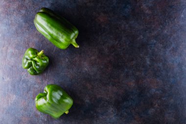 Karanlık arka planda çirkin dolmalık biber. Deforme olmuş yeşil dolmalık biber. Gıda organik atıklarının azaltılması kavramı. GDO olmayan sebzeler. Uzayı kopyala Üst görünüm