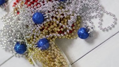 Beyaz tahtalarda yeni yıl süslemeleri. Gözlüklü, çok renkli boncuklar. Beyaz arka planda bir Noel ağacı için dekorasyonlar