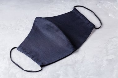 Nihai gri arka planda yüz koruyucu maskesi. Siyah pamuktan yapılmış antivirüs maskesi. Siyah yüz, grip ve virüse karşı korumak için ev yapımı bir maske. Uzayı kopyala Üst görünüm